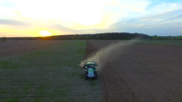 Воздушный Дрон Запечатлел Зеленый Трактор Работающий Поле Пахающий Закате — стоковое видео