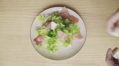 Erkek el salata parma jambonu veya ahşap masa, üstten görünüm üzerinde jamon camembert peyniri ekleyin