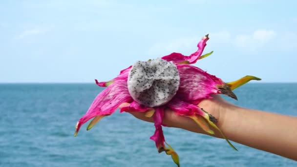 妇女手举行龙果子 海洋背景 — 图库视频影像