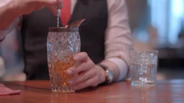 Beyefendi barmen küre buz, buz kalıbı ile viski bir bardak hazırlanıyor
