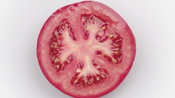 成熟的多汁番茄切成两半旋转在白色背景隔离特写顶视图 — 图库视频影像