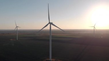 Beyaz rüzgar enerji güç kuleleri bir grup gün batımı, gün doğumukarşı alanında değirmenler. Yeşil, temiz, yenilenebilir enerji. Havadan çekilen görüntüler.