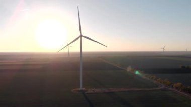 Beyaz rüzgar enerji güç kuleleri bir grup gün batımı, gün doğumukarşı alanında değirmenler. Yeşil, temiz, yenilenebilir enerji. Havadan çekilen görüntüler.