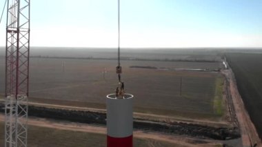 Yapım aşamasında rüzgar enerjisi güç kulesi değirmeni yapım süreci. Montaj kulesi, sütun, sütun. Yeşil, temiz, yenilenebilir enerji. Havadan çekilen görüntüler.