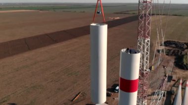 Yapım aşamasında rüzgar enerjisi güç kulesi değirmeni yapım süreci. Montaj kulesi, sütun, sütun. Yeşil, temiz, yenilenebilir enerji. Havadan çekilen görüntüler.