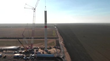 Yapım aşamasında rüzgar enerjisi güç kulesi değirmeni yapım süreci. Montaj kulesi, sütun, sütun. Yeşil, temiz, yenilenebilir enerji. Havadan çekilen görüntüler.