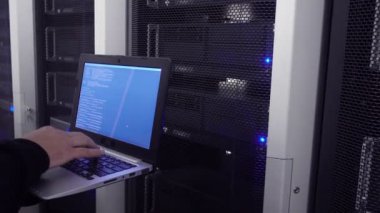 Veri merkezi mühendis Laptop tutar ve sistemin kararlılığını test eder. Görüntünün hafif bir ses var.