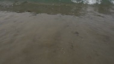 Köpük dalgalar deniz güneşli bir gün plajda. Ağır çekim 250fps 