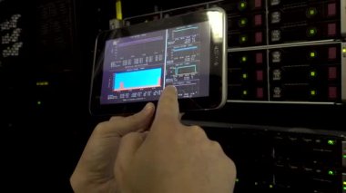 Mühendis tutar tablet pc ve bir tarama yapar. Sunucu odasına mühendislik. Elinde bir tablet bilgisayar. Led göstergesi arka plan. Titreşim video olduğunu.