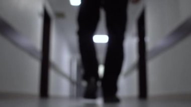 Bir iş merkezinin koridorunda yürüyen bir işadamı. Alt görünüm. İnsan basamakları. Bulanık arka plan 4k