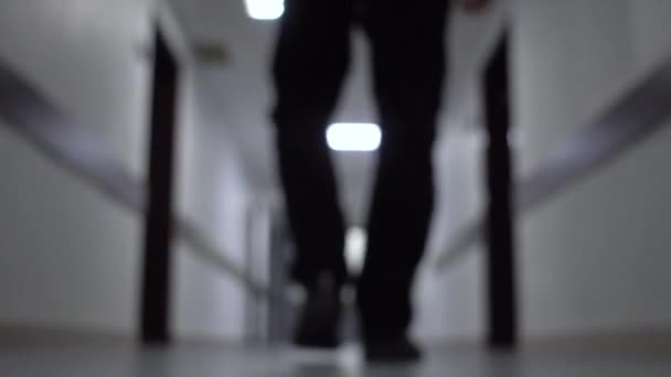 Επιχειρηματίας που περπατάει στο διάδρομο ενός επιχειρηματικού κέντρου. Η κάτω όψη. Ανθρώπινα βήματα. Θολή φόντο 4K — Αρχείο Βίντεο