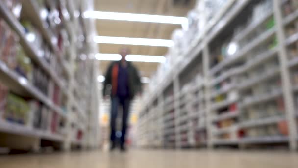 No supermercado: Homem caminhando na loja de supermercados. Fundo desfocado — Vídeo de Stock