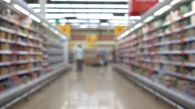 Alışveriş arabalı insanlar. İnsanlar bir süpermarkette alışveriş yapıyor, bulanık arka planda..