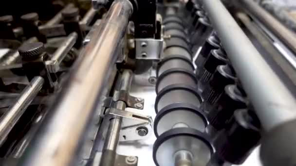 Stroje v tiskárně. Papírový skládací válečkový pásový dopravník. — Stock video