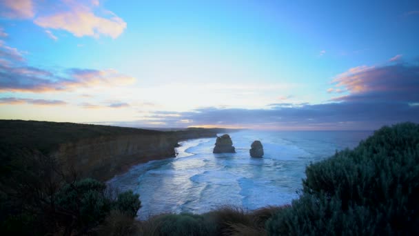 偉大な海の道ビクトリア オーストラリアで日の出と石灰岩の崖で十二使徒定員会岩柱の周りの海の波 — ストック動画