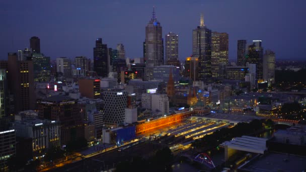 メルボルン オーストラリア 2018 夜電車フリンダース ストリート駅とオーストラリア ビクトリア州のメルボルンの中央ビジネス地区高層ビルの夜景を残して — ストック動画