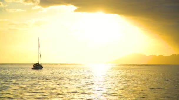 金黄天空一个玻利尼西亚的日落看法礁石和游艇在一个热带海岛天堂莫雷阿岛从塔希提岛南太平洋太阳耀斑 — 图库视频影像