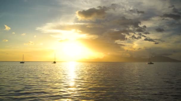 金黄天空一个玻利尼西亚的日落看法礁石和游艇在一个热带海岛天堂莫雷阿岛从塔希提岛南太平洋太阳耀斑 — 图库视频影像