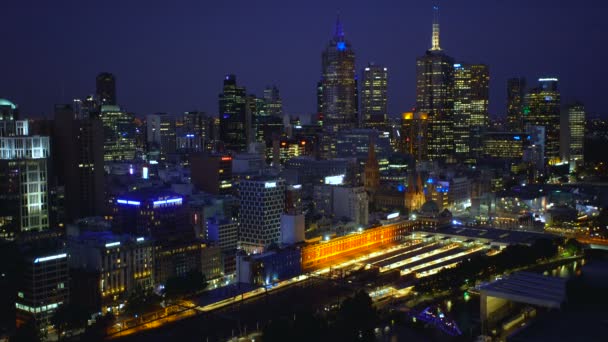 フリンダース ストリート鉄道駅プラットフォーム オーストラリア ビクトリア州の照らされたライトと夜メルボルン オーストラリア 2018 メルボルンの中央ビジネス地区のスカイライン — ストック動画