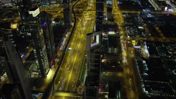 空中照らされた夜俯瞰市超高層ビル高速道路車両交通地下鉄レール マンション エリア近代的な輸送システム アラブ首長国連邦ドバイ — ストック動画