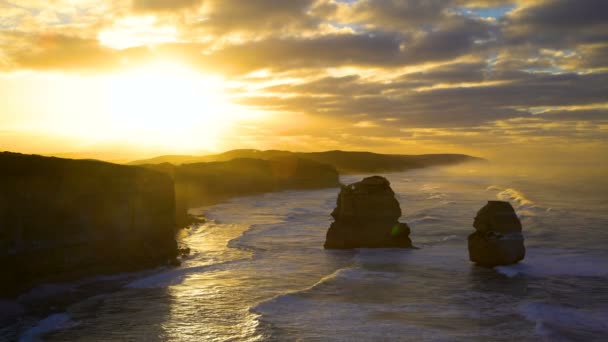 石灰岩の崖と岩 使徒海洋国立公園オーストラリアの朝雲の切れ間から太陽の光 — ストック動画