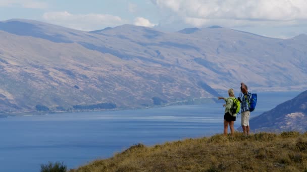 健康白种男性和女性高级旅行者徒步旅行使用双筒望远镜户外瓦卡蒂普湖有抱负的湖泊新西兰 — 图库视频影像