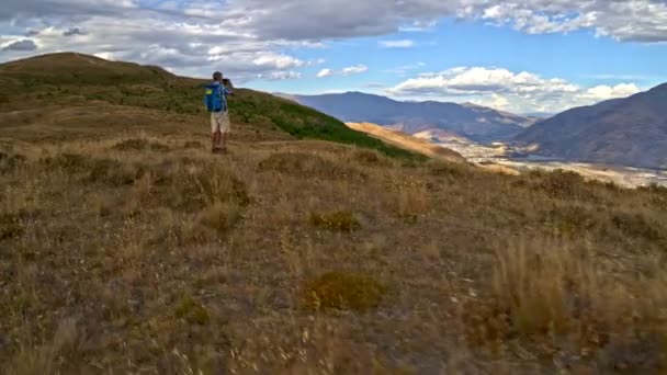 フィット成熟した白人カップル トレッキング見てパノラマ双眼鏡屋外 リマーカブルズ オタゴ ニュージーランドでの空中ドローン — ストック動画