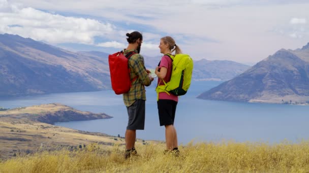 アクティブな白人冒険旅行 ハイキングを楽しむ マウント アスパイア リング湖ワカティプ ニュージーランドの地図を読んでのツアーを計画 — ストック動画