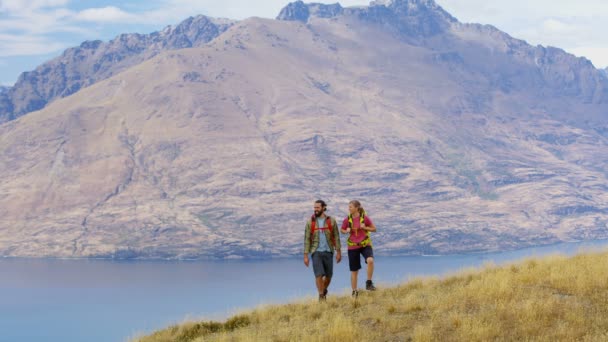 年轻的白种冒险的男性和女性旅行者徒步旅行和计划的游览在 Remarkables 湖瓦卡蒂普新西兰 — 图库视频影像