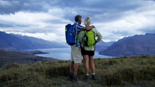 快乐的白种老人穿着休闲服装徒步旅行 以保持健康的山有抱负的湖瓦卡蒂普奥塔哥新西兰 — 图库视频影像