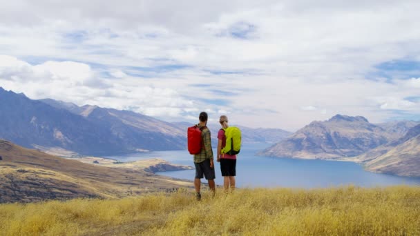 ニュージーランド ワカティプ湖のきれいな自然の中でトレッキングを楽しんでいるバックパックと若い白人アドベンチャー ハイカー — ストック動画