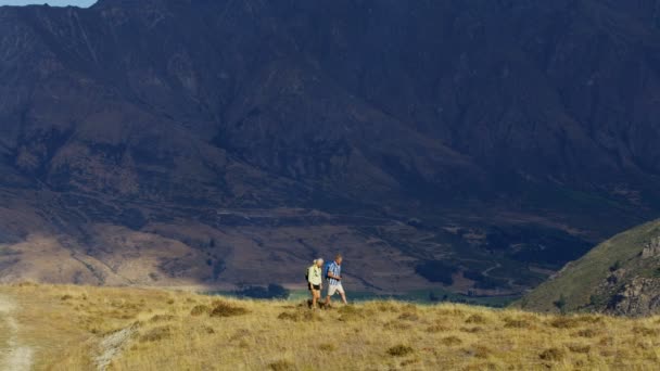 アクティブな退職を楽しんでリュックサックで白人カップルを引退したリマーカブルズ湖ワカティプ新しいニュージーランドのトレッキング — ストック動画