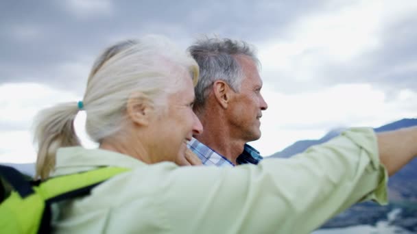 快乐退休的白种夫妇与背囊享受退休徒步旅行的 Remarkables 湖瓦卡蒂普新西兰 — 图库视频影像