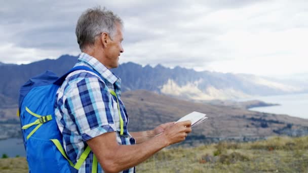 Kaukaski Starszy Mężczyzna Podróżnych Korzystających Turystyka Planowania Podróży Czytania Mapy — Wideo stockowe