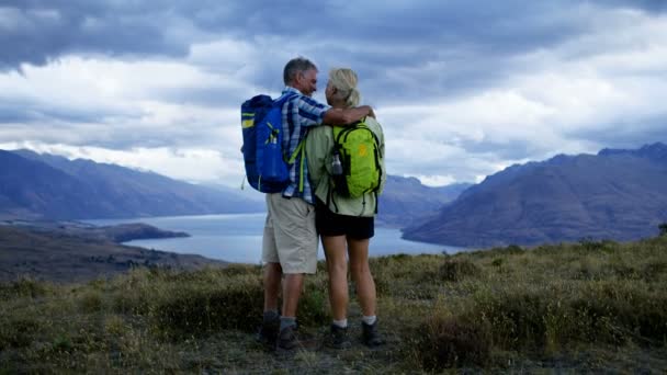 快乐健康的白种男性和女性高级徒步旅行者一起渡假徒步旅行瓦卡蒂普新西兰的抱负湖 — 图库视频影像