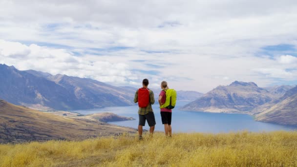 年轻快乐高加索冒险夫妇在他们的假期徒步旅行 Remarkables 湖瓦卡蒂普奥塔哥新西兰 — 图库视频影像
