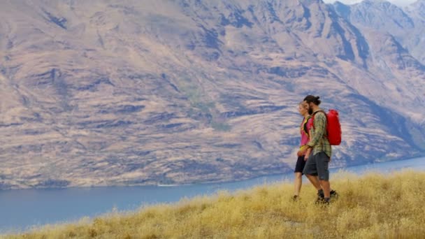 年轻的高加索夫妇徒步旅行者与背囊在他们的徒步探险远征在 Remarkables 奥塔哥新西兰 — 图库视频影像