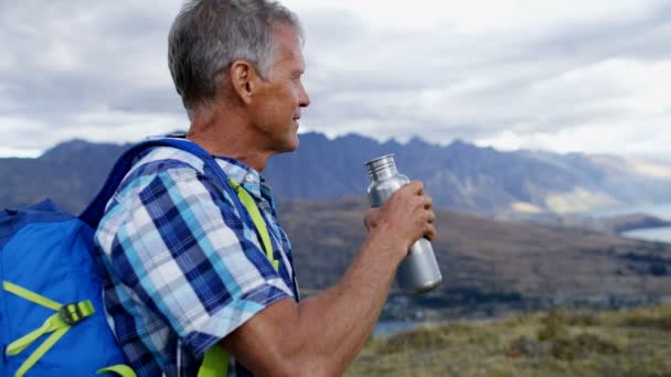 适合成熟的高加索男性与热水瓶打破福德岛 Remarkables 湖瓦卡蒂普新西兰的徒步旅行 — 图库视频影像
