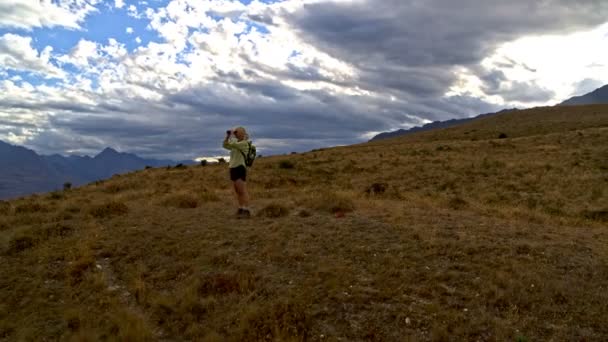 空中无人机适合退休的白种女人与望远镜享受徒步的 Remarkables 湖瓦卡蒂普新西兰 — 图库视频影像