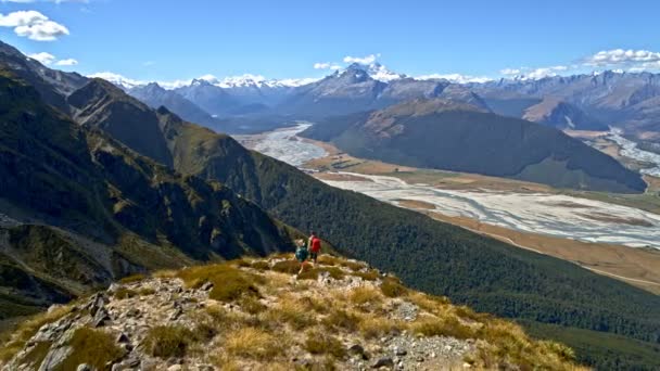 志望のニュージーランドのマウントのきれいな風景の中のハイキングを楽しむリュックサックとアクティブな白人ハイカーの空中ドローン — ストック動画