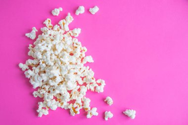 Arka plan ile bir patlamış mısır. Patlamış mısır ile pembe arka plan.