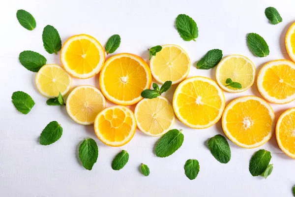 White background with lemon, orange slices and mint. Concept with fresh fruit. Lemon, Orange, Mint.