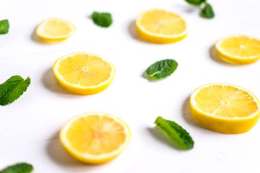 Beyaz bir arka plan üzerinde taze limon dilimleri. Limon ve nane ile arka plan. Narenciye ile güzel bir fotoğraf. C vitamini