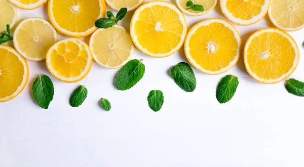 White background with lemon, orange slices and mint. Lemon, Orange, Mint. View from above