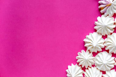 Bir beze desteğiyle pembe bir arka plan üzerinde için çerçeve. Pembe bir arka plan üzerinde renkli meringues tasarımı için temel.