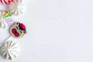 Çerçeve rengi meringues aksanlı. Tatlılar ile bir başlık için arka plan. Beyaz ahşap zemin üzerinde çok renkli meringues.