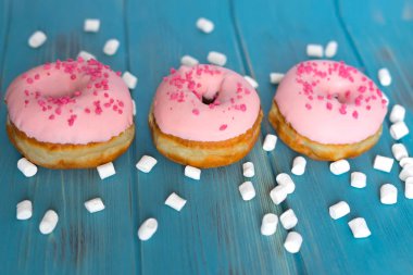 Fotoğraf Donuts mavi ahşap arka plan üzerinde. Tatlılar. Donuts blog için fotoğraf
