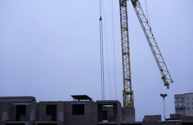 Akşam bir inşaat sahasında bir Vinçler fotoğraf. Yüksek katlı binaların inşası için kötü hava fotoğrafları.