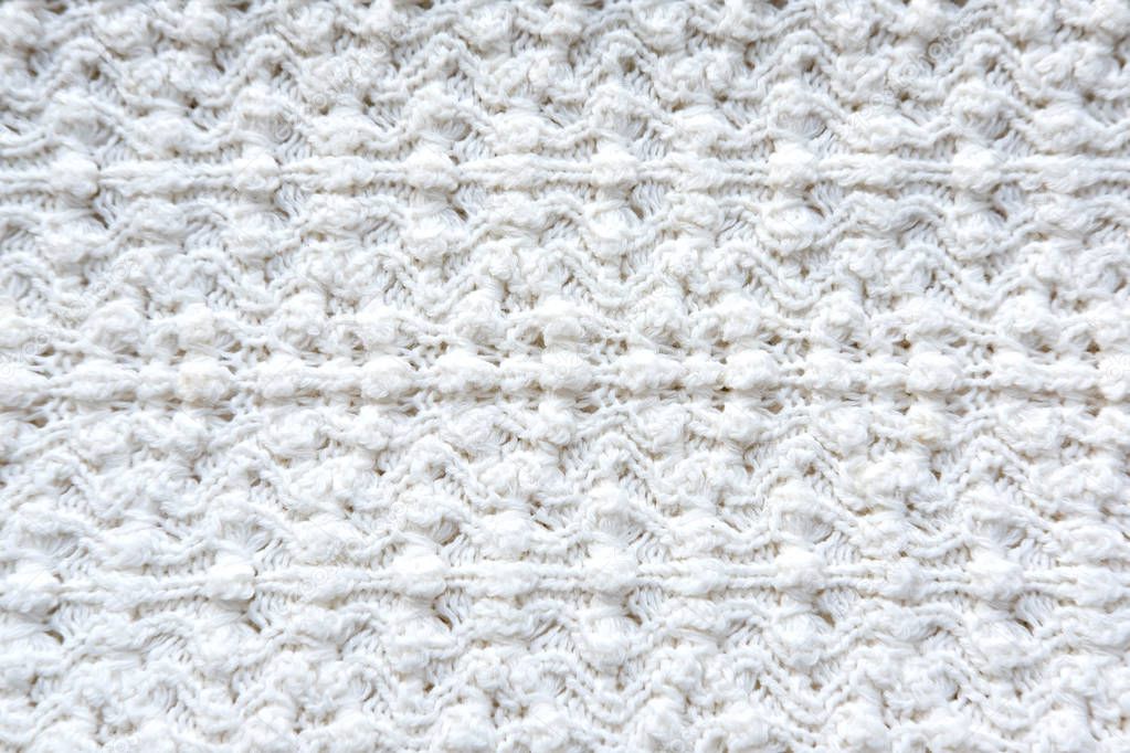 Texture knitted fabric. Figured knitting for a product. Textured cotton warm knitted fabric.