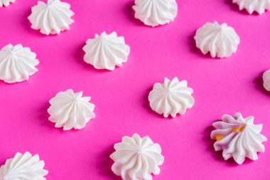Desen meringues üzerinde pembe bir arka plan ile. Çok renkli meringues pembe bir arka plan üzerinde. Şekerleme afiş, kafe, tatlı dükkanı için temel.